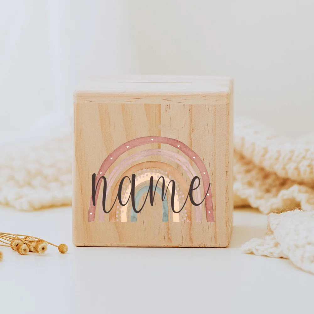 Descubra o Mealheiro Infantil Personalizado - Arco-Íris, feito em madeira maciça e personalizado com o nome da criança. Um presente único e educativo para decorar o quarto do bebé e incentivar a poupança. Ideal para nascimentos, batizados e aniversários!