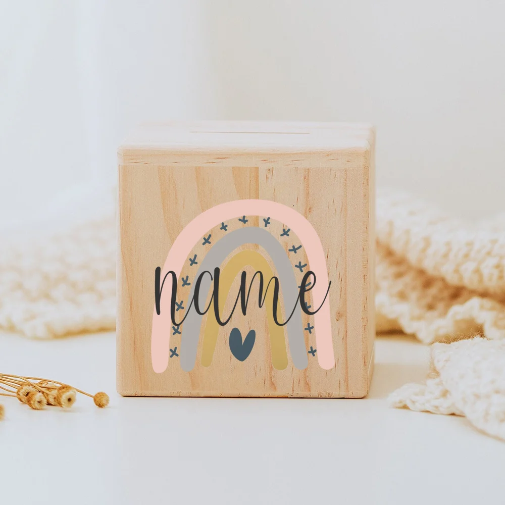 Descubra o Mealheiro Infantil Personalizado - Arco-Íris, feito em madeira maciça e personalizado com o nome da criança. Um presente único e educativo para decorar o quarto do bebé e incentivar a poupança. Ideal para nascimentos, batizados e aniversários!