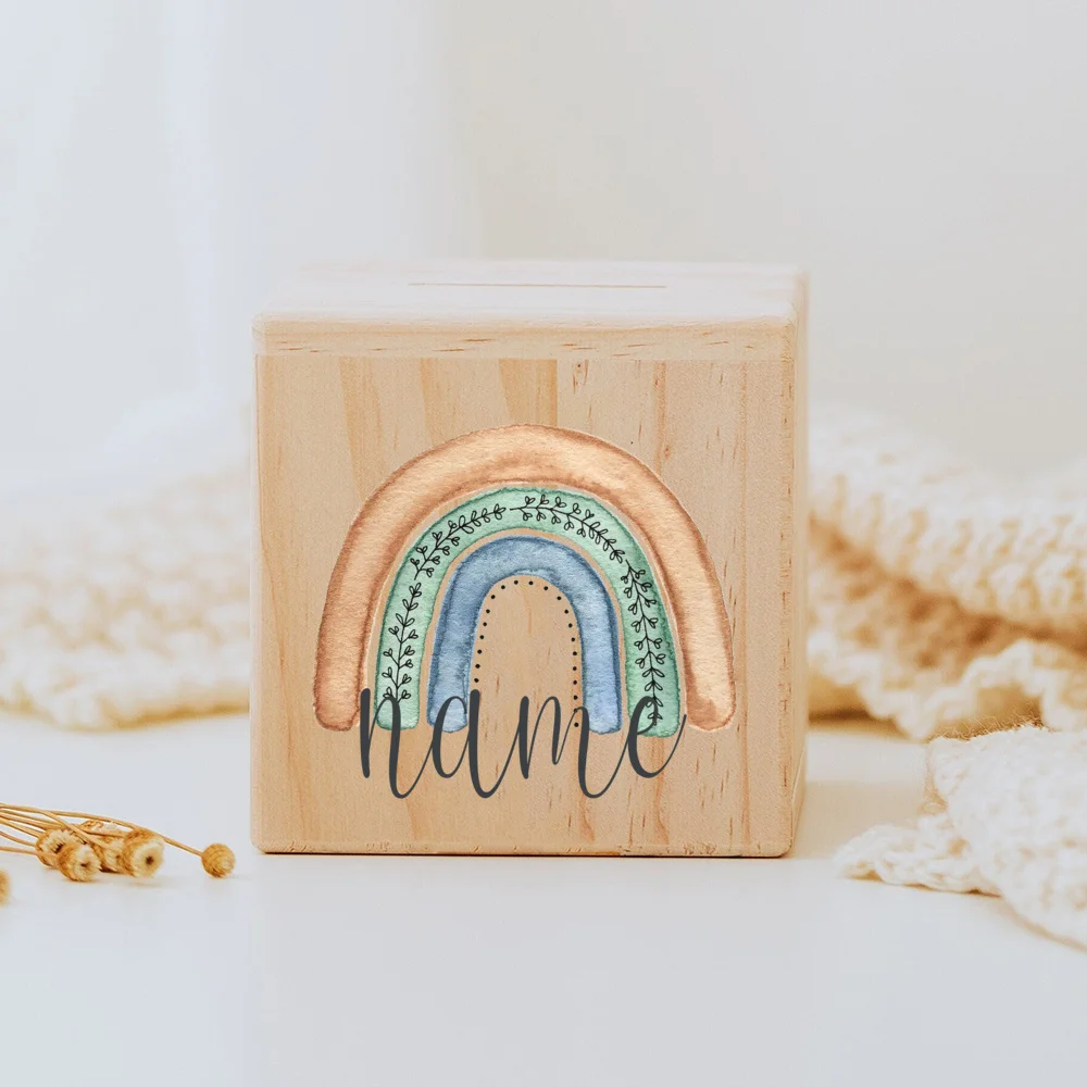 Descubra o Mealheiro Infantil Personalizado - Arco-Íris, feito em madeira maciça e personalizado com o nome da criança. Um presente único e educativo para decorar o quarto do bebé e incentivar a poupança. Ideal para nascimentos, batizados e aniversários!