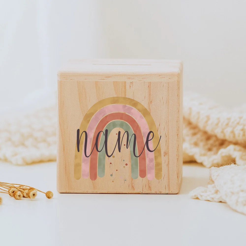 Descubra o Mealheiro Infantil Personalizado - Arco-Íris, feito em madeira maciça e personalizado com o nome da criança. Um presente único e educativo para decorar o quarto do bebé e incentivar a poupança. Ideal para nascimentos, batizados e aniversários!