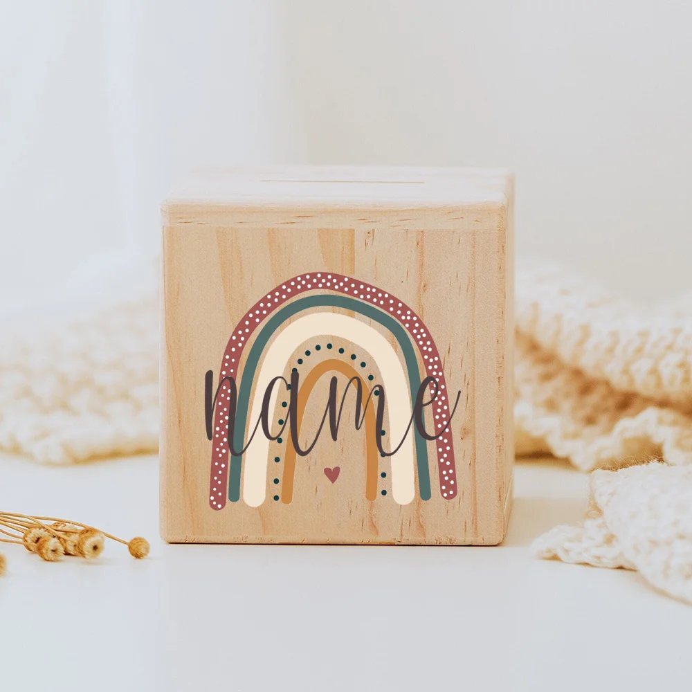 Descubra o Mealheiro Infantil Personalizado - Arco-Íris, feito em madeira maciça e personalizado com o nome da criança. Um presente único e educativo para decorar o quarto do bebé e incentivar a poupança. Ideal para nascimentos, batizados e aniversários!