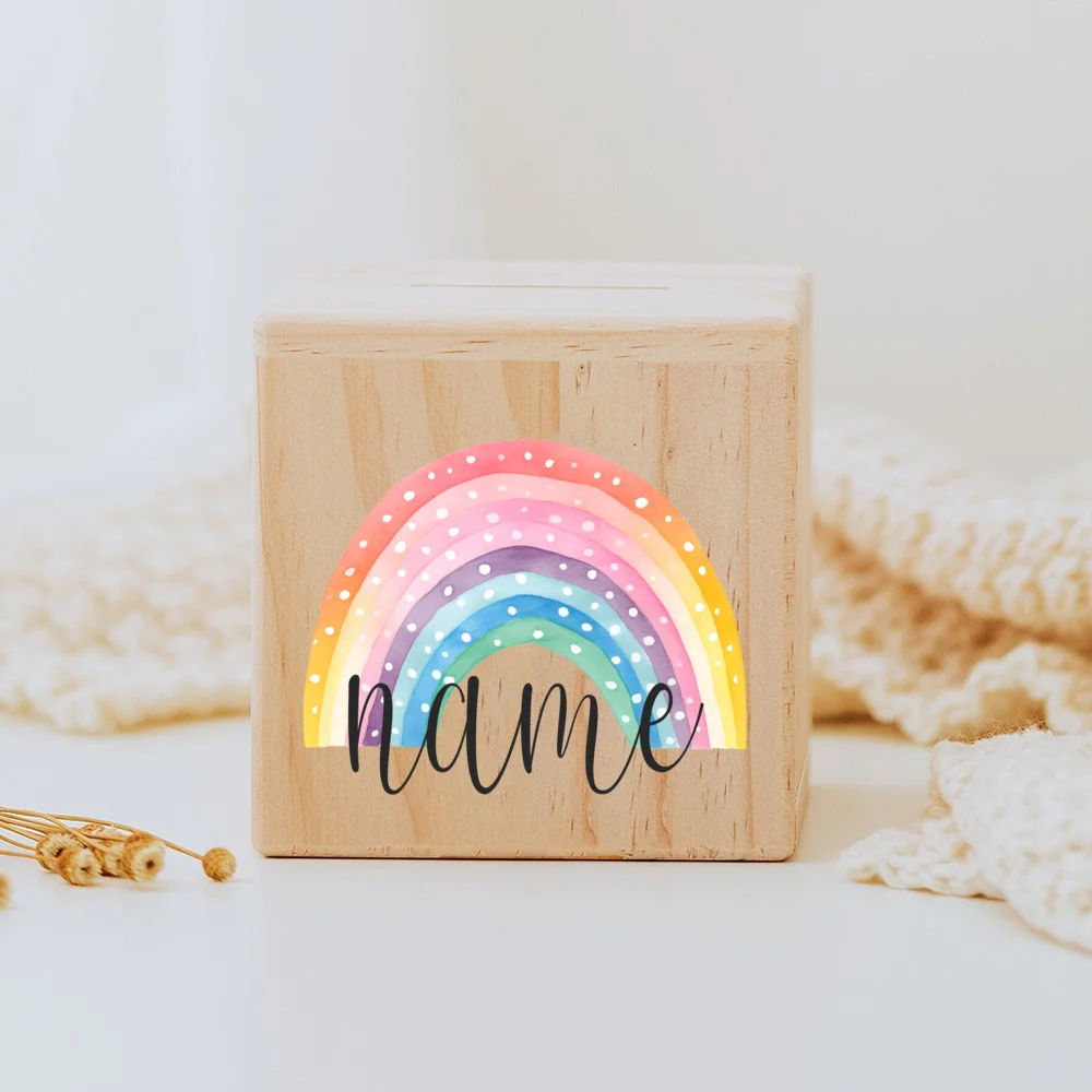 Descubra o Mealheiro Infantil Personalizado - Arco-Íris, feito em madeira maciça e personalizado com o nome da criança. Um presente único e educativo para decorar o quarto do bebé e incentivar a poupança. Ideal para nascimentos, batizados e aniversários!