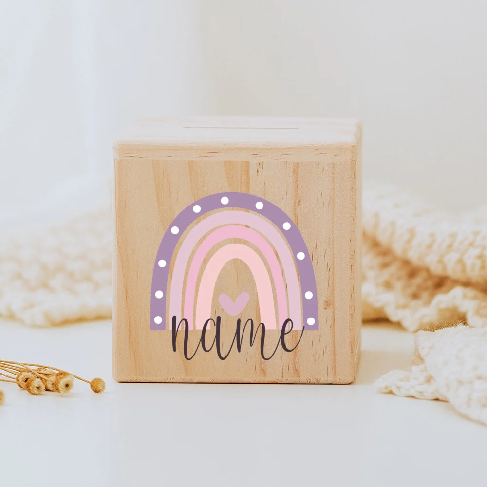 Descubra o Mealheiro Infantil Personalizado - Arco-Íris, feito em madeira maciça e personalizado com o nome da criança. Um presente único e educativo para decorar o quarto do bebé e incentivar a poupança. Ideal para nascimentos, batizados e aniversários!