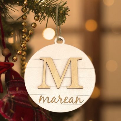 Descobre o ornamento de Natal personalizado com inicial em relevo e nome gravado. Ideal para decorar a árvore ou oferecer como presente único e memorável. Encomenda já na Prendas Originais.