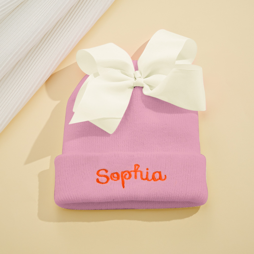 Personalize um adorável gorro de bebé com nome bordado e laço decorativo. Um presente original para nascimento, batizado, aniversário ou baby shower.