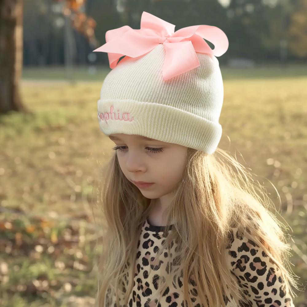 Personalize um adorável gorro de bebé com nome bordado e laço decorativo. Um presente original para nascimento, batizado, aniversário ou baby shower.