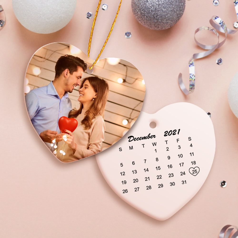 Personalize um ornamento de cerâmica em forma de coração com fotografia e calendário. Um presente único para celebrar datas especiais e decorar o Natal com emoção. Descubra na Prendas Originais.